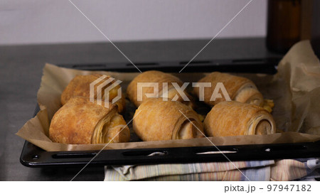 Homemade pastry puff buns with cheese on a baking sheet close-up Homemade pastry puff buns with cheese on a baking sheet close-up 97947182