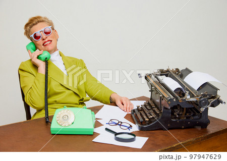 Creative portrait of fashionable middle age woman in vintage style clothes among retro interior objects over light background. Business, fashion concept Creative portrait of fashionable middle age woman in vintage style clothes among retro interior objects over light background. Business, fashion concept 97947629