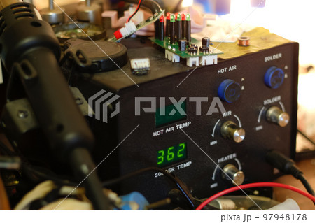 Defocus soldering Station. Soldering iron digital station on the workplace. Soldering station with LED display, heating control regulator, with hot air gun and soldering iron. Out of focus Defocus soldering Station. Soldering iron digital station on the workplace. Soldering station with LED display, heating control regulator, with hot air gun and soldering iron. Out of focus 97948178