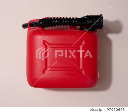 Red plastic canister for liquid fuels and lubricants on a beige background Red plastic canister for liquid fuels and lubricants on a beige background 97950603