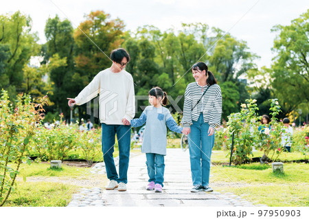 仲良く公園を散歩する家族 97950903