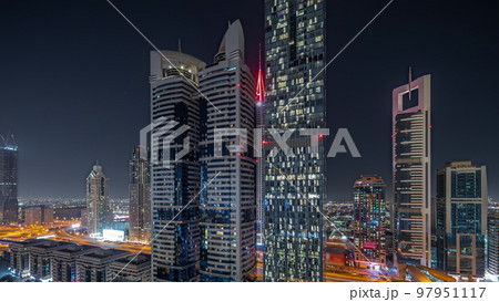 Panorama showing aerial view of Dubai International Financial District with many skyscrapers night timelapse. Panorama showing aerial view of Dubai International Financial District with many skyscrapers night timelapse. 97951117