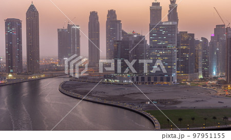 Cityscape of skyscrapers in Dubai Business Bay with water canal aerial day to night timelapse Cityscape of skyscrapers in Dubai Business Bay with water canal aerial day to night timelapse 97951155