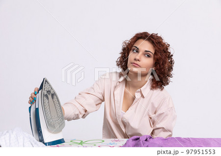 Boring household chores. Pause while ironing men's shirts. 97951553
