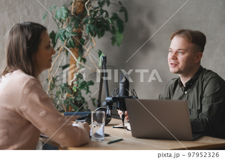 record podcast in recording studio. man and woman do interviews or create audio content in studio record podcast in recording studio. man and woman do interviews or create audio content in studio 97952326