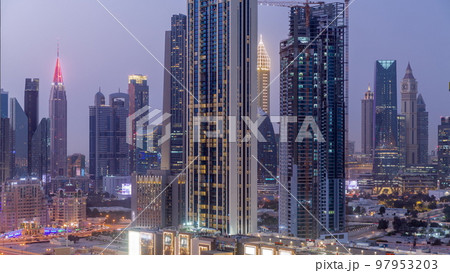 Row of the tall buildings around Sheikh Zayed Road and DIFC district aerial day to night timelapse in Dubai 97953203