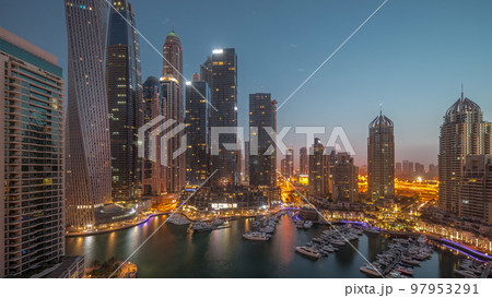 Dubai marina tallest skyscrapers and yachts in harbor aerial night to day timelapse. Dubai marina tallest skyscrapers and yachts in harbor aerial night to day timelapse. 97953291