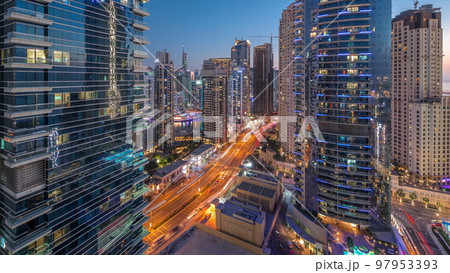 Panoramic view of the Dubai Marina and JBR area and the famous Ferris Wheel aerial day to night timelapse 97953393