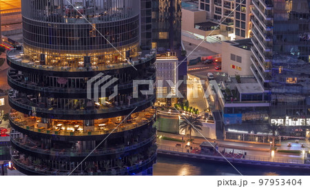 Dubai marina waterfront and building with different restaurants at each floor aerial night to day timelapse. Dubai marina waterfront and building with different restaurants at each floor aerial night to day timelapse. 97953404