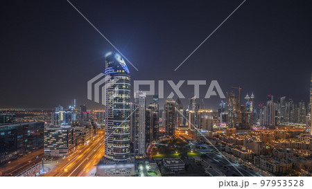 Panorama showing Dubai's business bay towers aerial night timelapse. Rooftop view of some skyscrapers Panorama showing Dubai's business bay towers aerial night timelapse. Rooftop view of some skyscrapers 97953528