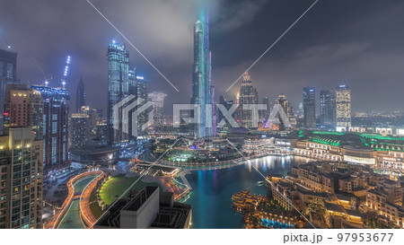 Skyscrapers rising above Dubai downtown night timelapse surrounded by modern buildings aerial top view Skyscrapers rising above Dubai downtown night timelapse surrounded by modern buildings aerial top view 97953677