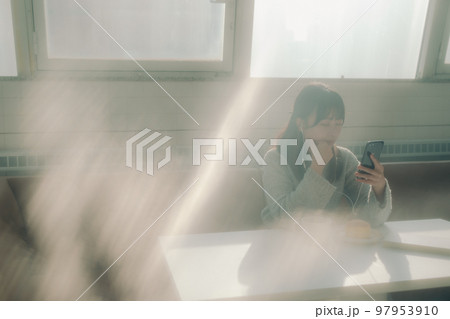 カフェで音楽を聴く若い女子大生の写真 97953910