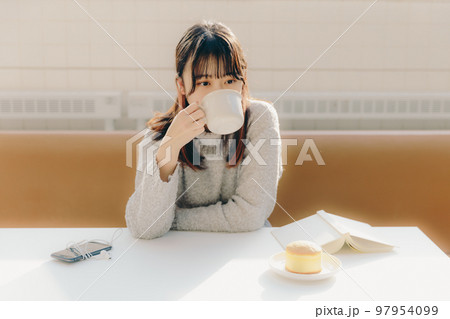 カフェで食べる若い女子大生の写真 カフェで食べる若い女子大生の写真 97954099