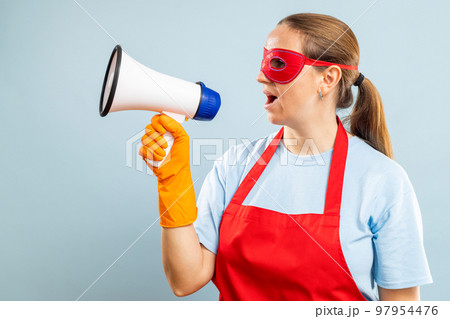 Woman in red mask, gloves and apron with megaphone on blue background Woman in red mask, gloves and apron with megaphone on blue background 97954476