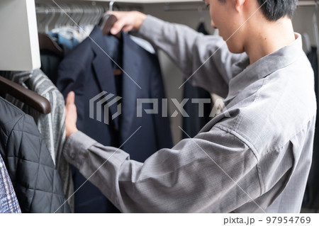 ウォークインクローゼットで服を選ぶ若い男性(ファッション・コーディネート) ウォークインクローゼットで服を選ぶ若い男性(ファッション・コーディネート) 97954769