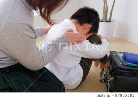 辛そうな小学生の男の子とその母親 97955385