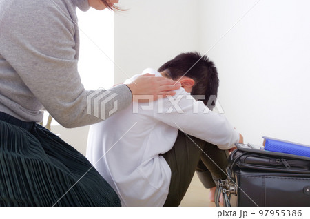 辛そうな小学生の男の子とその母親 97955386