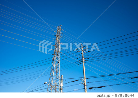 住宅街の電線と高圧送電線を支える送電鉄塔 見上げる快晴の空　 97958644