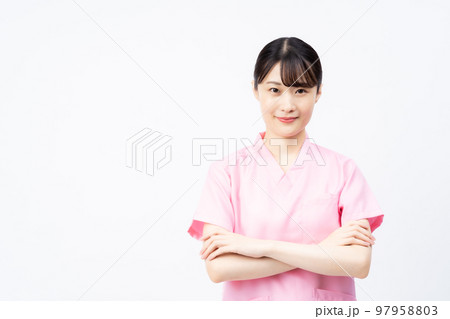 腕を組むピンクのスクラブを着た若い女性の看護師 腕を組むピンクのスクラブを着た若い女性の看護師 97958803