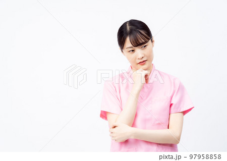 ピンクのスクラブを着た若い女性の看護師（悩む、困る） 97958858
