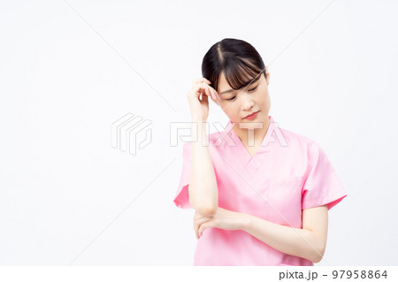 ピンクのスクラブを着た若い女性の看護師(悩む、困る) ピンクのスクラブを着た若い女性の看護師(悩む、困る) 97958864