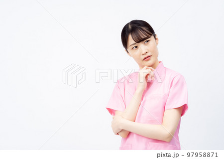 ピンクのスクラブを着た若い女性の看護師(悩む、困る) ピンクのスクラブを着た若い女性の看護師(悩む、困る) 97958871