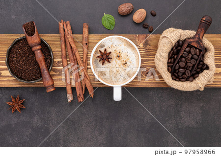 Roasted coffee beans with coffee powder and flavourful ingredients for make tasty coffee setup on dark stone background. 97958966