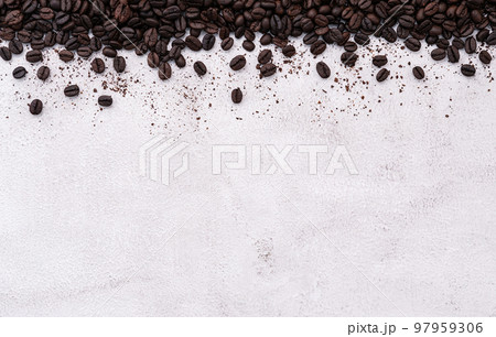 Dark roasted coffee beans setup on white concrete background with copy space. 97959306