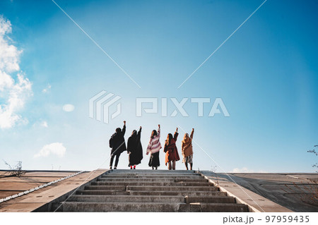 友人5人で青空のもと楽しそうに階段を駆け上がる 97959435