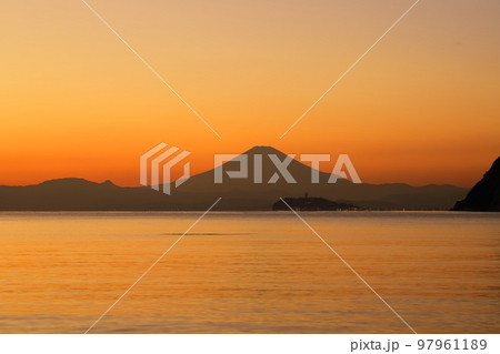 冬の夕暮れの逗子海岸、夕焼けに染まる空に浮かぶ富士山のシルエット 97961189