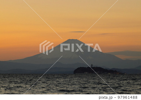 冬の逗子海岸の夕暮れ、オレンジ色に染まる空と海に浮かぶ富士山のシルエット 97961488