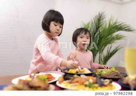 テーブルに並べられたクリスマスの料理を食べる子供 テーブルに並べられたクリスマスの料理を食べる子供 97962298