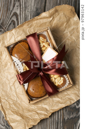 Homemade caramel. Brown caramel candies. Creamy sweets with peanuts. On pine boards. Packed in a box and tied with a ribbon. Homemade caramel. Brown caramel candies. Creamy sweets with peanuts. On pine boards. Packed in a box and tied with a ribbon. 97963142