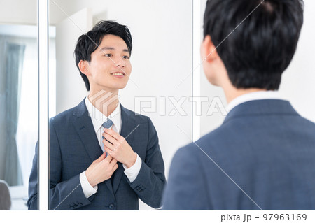 洗面所で鏡を見てネクタイを締める若いビジネスマン(朝・出勤準備) 洗面所で鏡を見てネクタイを締める若いビジネスマン(朝・出勤準備) 97963169