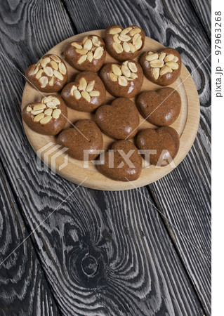 Homemade caramel. Brown caramel candies. Creamy sweets with peanuts. On pine boards. Homemade caramel. Brown caramel candies. Creamy sweets with peanuts. On pine boards. 97963268