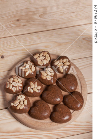 Homemade caramel. Brown caramel candies. Creamy sweets with peanuts. On pine boards. Homemade caramel. Brown caramel candies. Creamy sweets with peanuts. On pine boards. 97963274