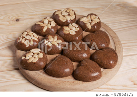 Homemade caramel. Brown caramel candies. Creamy sweets with peanuts. On pine boards. Homemade caramel. Brown caramel candies. Creamy sweets with peanuts. On pine boards. 97963275