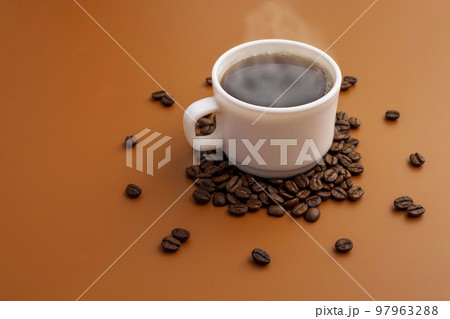Coffee cup and roasted beans arranged as clock face on brown background 97963288