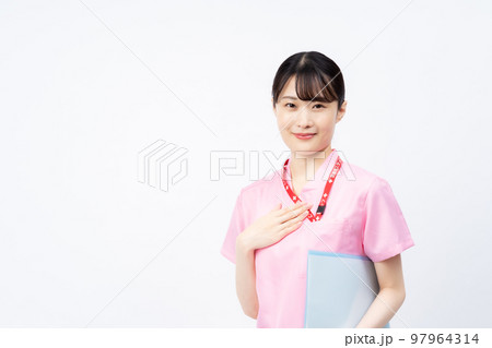 手を胸に当てるピンクのスクラブを着た若い女性の看護師 97964314