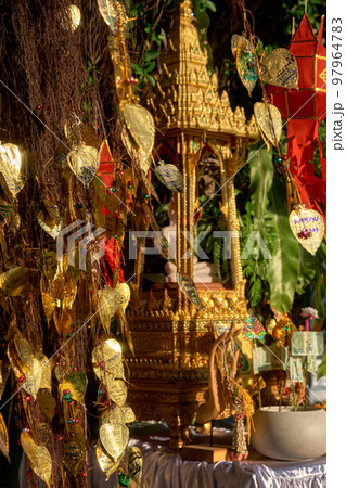 Thai Buddha altar, offerings, lanterns, golden leaves of Bodhi tree.  97964783