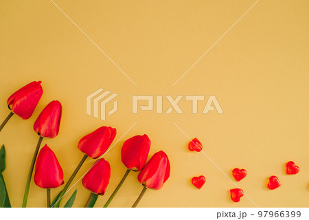 Valentine's Day. Flowers composition. Frame made of red flowers, heart on yellow background. Flat flat, top view, copy space. 97966399