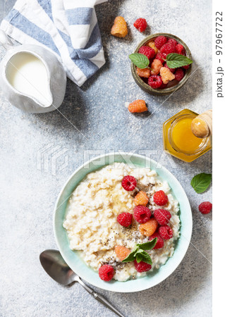 Healthy diet breakfast. Oatmeal porridge in ceramic bowl decorated with fresh berries raspberries and chia seeds served with honey. View from above. Copy space. 97967722