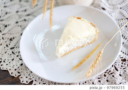 Clear Coconut Cream Pie in the dish on the wood table without anything topping on it. Shooting in the sunlight. 97969255