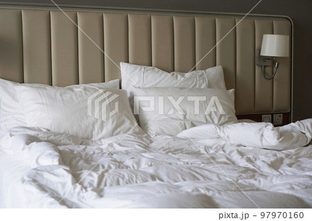 Wrinkled bed in a hotel room or at home. White linens. Wrinkled bed in a hotel room or at home. White linens. 97970160