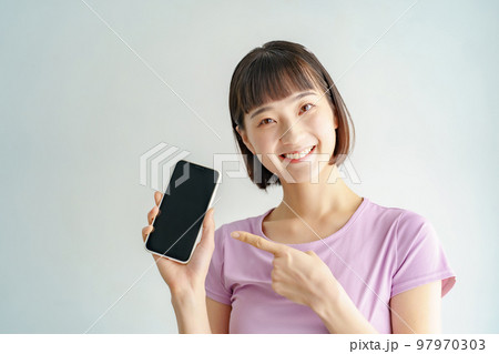 スポーツウェア姿でスマートフォンを持つ女性 97970303