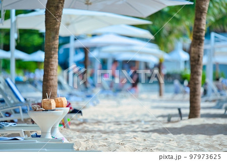 アジアのリゾートホテルの砂浜にあるデッキチェアとココナッツの実 97973625