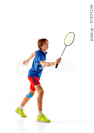 Portrait of teen boy in uniform playing badminton, training, posing with racket isolated over white background. Winner 97974146