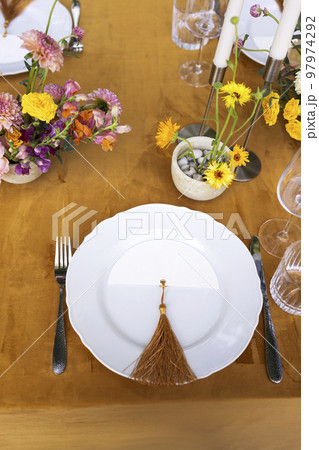 hairs and a table for guests, decorated with candles, are served with cutlery and crockery 97974292