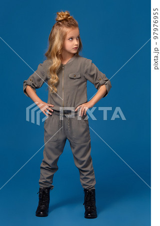 Little girl in a fashionable clothes on blue background Little girl in a fashionable clothes on blue background 97976955