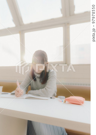 カフェで勉強をする若い女子大生の写真 97978550